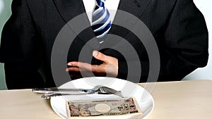 An image of a businessman who refuses to eat an extravagant meal