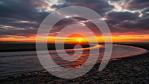 Sunset over calm water with rocky shore