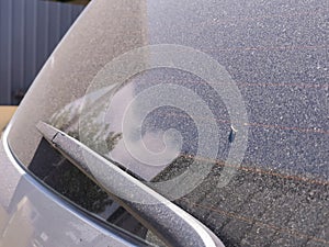 Image of car rear glass covered with dust. Dirty window.