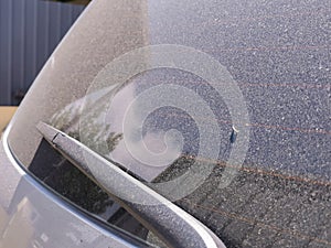 Image of car rear glass covered with dust. Dirty window. photo