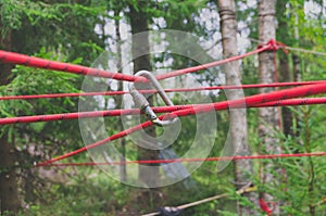 The image is a carabiner hook with a red rope for climbing and safety