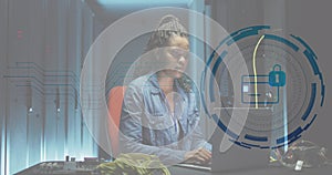 Image of card, padlock in circle, african american female engineer using laptop at data centre