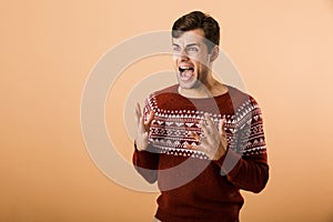 Image of caucasian man 20s with stubble wearing knitted sweater