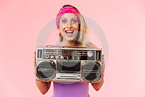 Image of charming excited woman holding retro tape-player