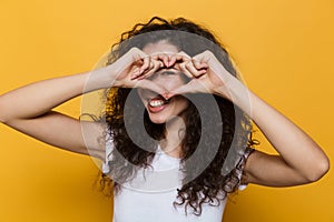 Image of charming woman 20s with curly hair smiling and showing