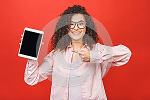 Image of cheerful amazed young curly caucasian woman showing display of tablet computer