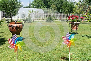 Image of childish colorful pinwheel on the outside. Garden with green grass in a sunny summer day. Rainbow flag LGBT Happy colors photo