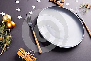 Image of christmas place setting with plate and cutlery on black background