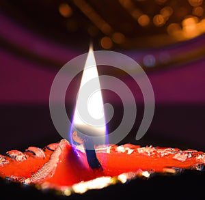 Image of close up of traditional lit indian candle on dark background