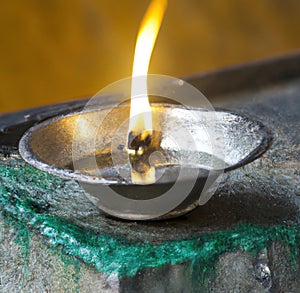 Image of close up of traditional lit indian candle on dark background