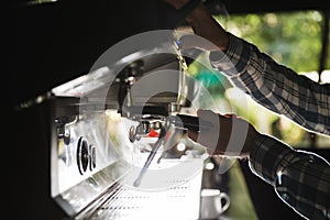 Image closeup of caucasian barista man making coffee while working in cafe or coffeehouse outdoor