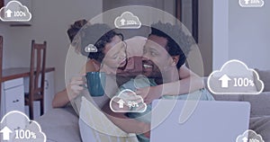 Image of cloud icons over african american couple using laptop
