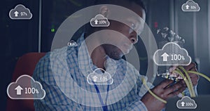 Image of cloud with uploading over african american man working in server room