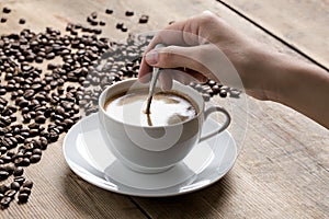 Obraz z káva pohár bytia podľa biely človek ruka na drevený stôl 