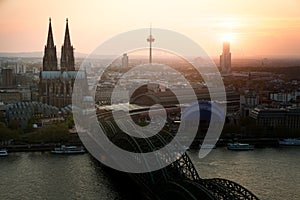 Image of Cologne with Cologne Cathedral with Rhine river and Hohenzollern bridge during sunset time in Germany.