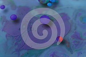 Colorful circles over turquoise and purple liquid