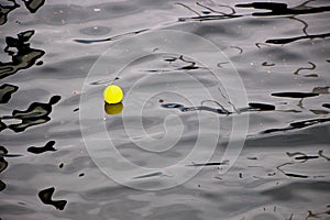 Image of a colorful yellow ball floating on the water