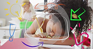 Image of colourful inspiration icons over busy biracial schoolgirl working in class