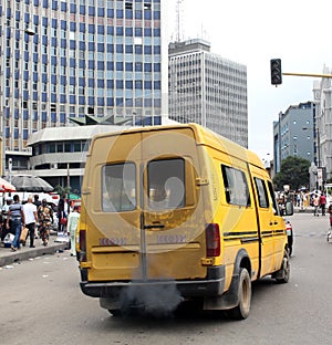 Image of a bus emitting smoke in a city