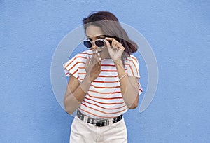 Image of confused african american woman in sunglasses looking at camera