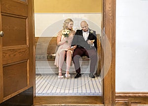 Image of couple  in vintage clothing sitting with man looking at marriage certificate