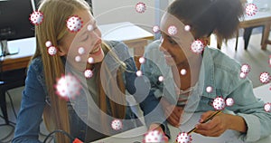 Image of Covid 19 coronavirus cells spreading over two female students working together