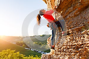 Image of curly-haired female tourist clambering over rock
