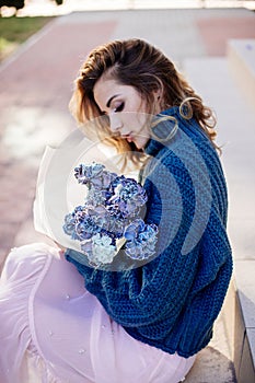 Image of cute woman with blue bouquet.