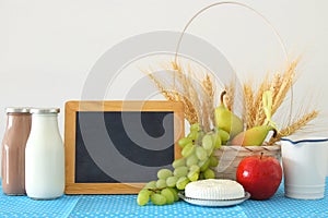 image of dairy products and fruits over wooden table. Symbols of jewish holiday - Shavuot.