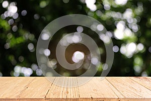 Image of dark wooden table in front of abstract blurred background of outdoor garden lights. can be used for display or montage y