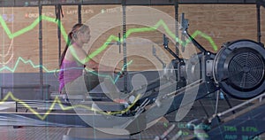 Image of data on graph over biracial woman training on rowing machine at gym