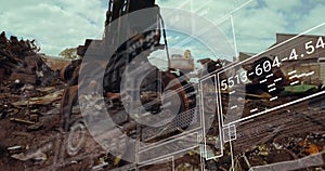 Image of data processing against hydraulic lifting machine with claw attachment at junkyard