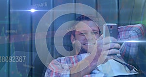 Image of data processing and light trails over caucasian man using smartphone