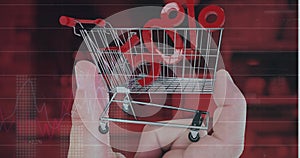 Image of data processing over 50 percent and hand with shopping cart