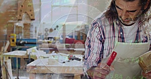 Image of data processing over caucasian male carpenter working in workshop