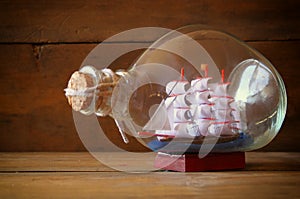 Image of decorative boat in the bottle on wooden table