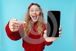 Image of delighted nice woman showing and pointing finger at cellphone