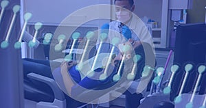 Image of DNA strand spinning over male dentist in face mask treating female patient in dentist chair