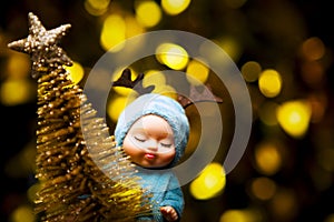 image of doll toy gold fir tree dark background