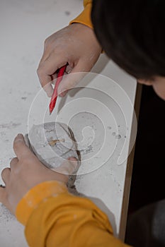 Image of an educational game to find fossils for a small archaeologist, with children`s hands digging