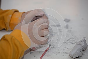Image of an educational game to find fossils for a small archaeologist, with children`s hands digging