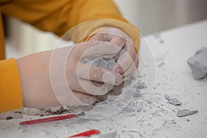 Image of an educational game to find fossils for a small archaeologist, with children`s hands digging