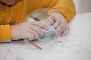 Image of an educational game to find fossils for a small archaeologist, with children`s hands digging