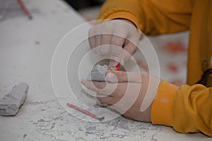 Image of an educational game to find fossils for a small archaeologist, with children`s hands digging