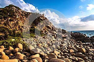 Nature Seascape with Rocks on A Wild Beach and A Rocky Cliff in The Morning Sunshine photo