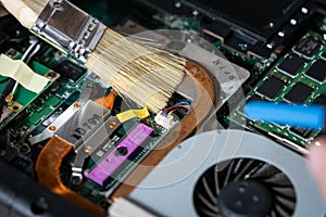 Image of an electrician cleaning a computer motherboard