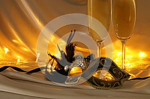 Image of elegant venetian mask and glasses of champagne over gol