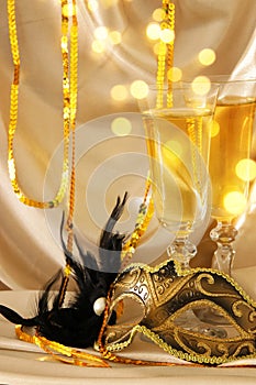 Image of elegant venetian mask and glasses of champagne over gol