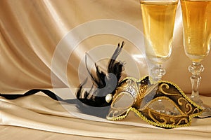 Image of elegant venetian mask and glasses of champagne over gol