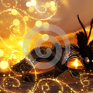 Image of elegant venetian mask over gold silk background.